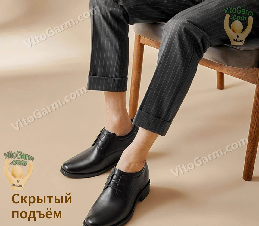 Чёрные кожаные туфли на модели в костюме, сидящей на стуле — скрытый подъём